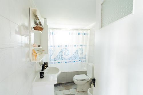 a white bathroom with a toilet and a shower at Villa Antheon in Kalamákion