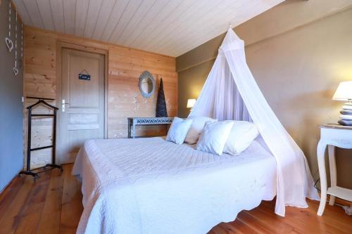 a bedroom with a white bed with a canopy at Appartement vue panoramique in Binos