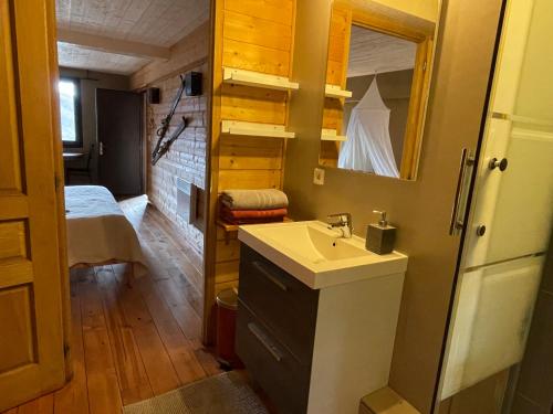 a bathroom with a sink and a mirror and a bed at Appartement vue panoramique in Binos