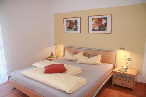 a bedroom with a bed with a red pillow on it at Ferienwohnungen Holder in Anhausen