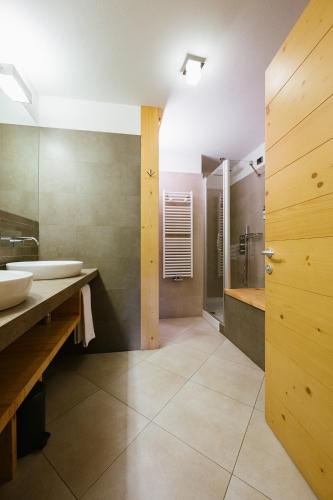un baño con dos lavabos y una ducha en Maribel Hotel, en Madonna di Campiglio