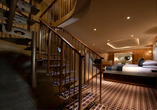 a bedroom with a bed and a staircase in a room at Fingal Hotel in Edinburgh