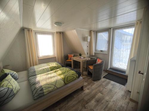 a bedroom with a bed and a table and window at Zingster Ostseeklause in Zingst