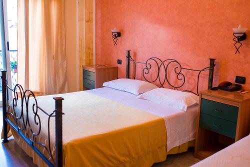 een slaapkamer met een groot bed met witte lakens bij Hotel Nizza in Nizza di Sicilia