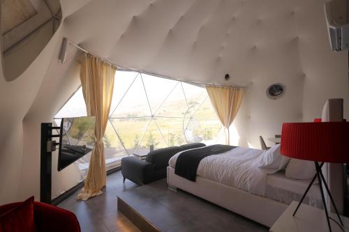 a bedroom with a bed and a large window at Lyv Resort and Venue in Şannīn