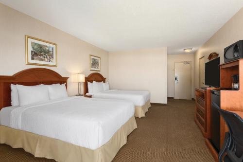 a hotel room with two beds and a flat screen tv at Days Inn by Wyndham London in London