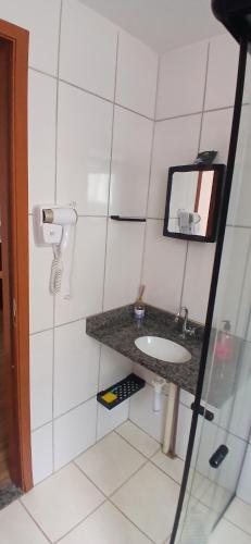 a bathroom with a sink and a mirror at Apartamento Tranquilidade! in Uberaba