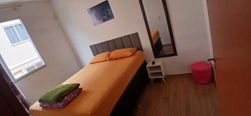 a bedroom with a bed in a room with a window at Apartamento Tranquilidade! in Uberaba