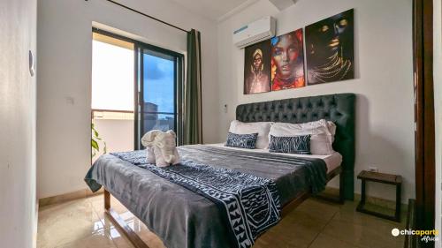 a bedroom with a bed with a green headboard at Chic studio with parking & balcony in Yaoundé
