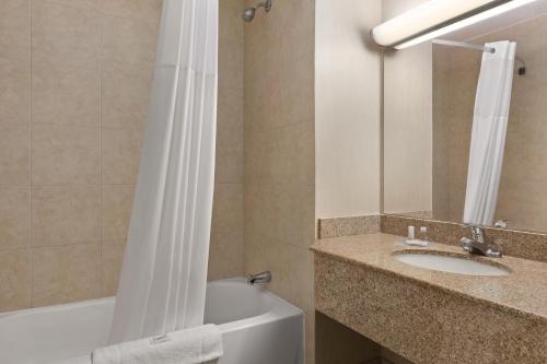 a bathroom with a sink and a toilet and a mirror at Days Inn by Wyndham London in London