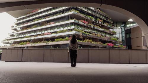 a woman standing in front of a tall building at Radisson Blu Hotel, Bergamo ChorusLife in Bergamo