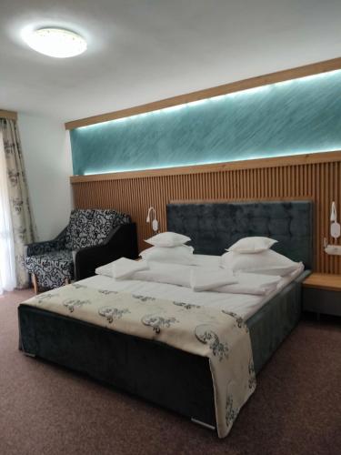 a bedroom with a large bed and a chair at Casa Rares in Moieciu de Sus