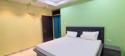 a bedroom with a bed with two pillows on it at Hanumant Dham in Dārāganj