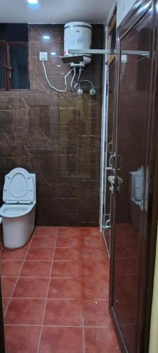 a bathroom with a toilet and a shower in it at Hanumant Dham in Dārāganj