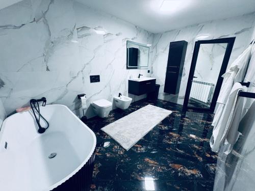 a white bathroom with a sink and a toilet at Casa Pop in Petrova