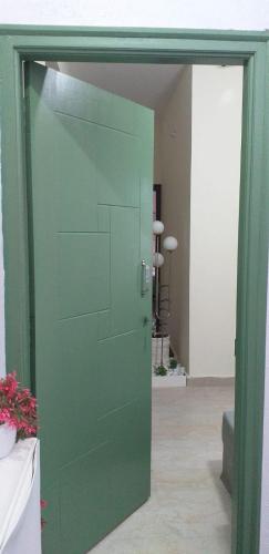 a green door leading into a room with a room with a table at Maple homes in Kammasandra