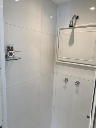 a bathroom with a shower with white tiles at Studio no Coração do Jardins Moderno e Sofisticado in São Paulo