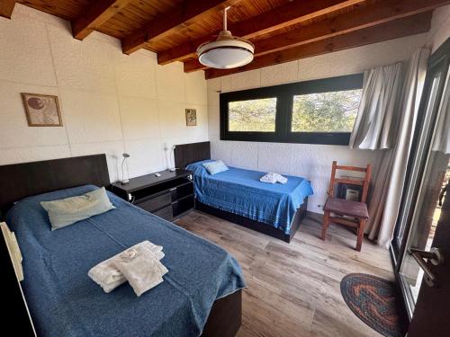 a bedroom with two beds and a window at La Morondanga in Villa Yacanto
