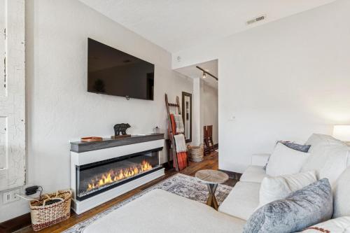 a living room with a fireplace with a tv on the wall at Bliss Retreat in Whitefish