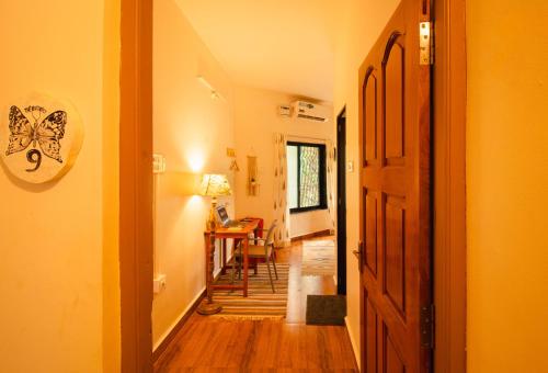 a hallway with a room with a butterfly sign on the wall at Odd Table-Social Homestay in Mandrem