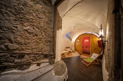 a room with a stone wall and an archway at Schloss Saalhof- Schlossflair, Wellnessauszeit, Bauernhofleben, Familienzeit im historischen Apartment zentral zwischen Zell am See und Saalbach-Hinterglemm in Maishofen