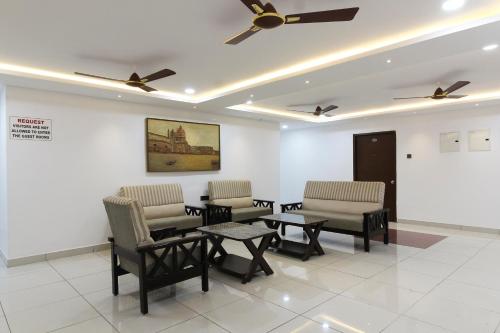 a waiting room with chairs and tables and a ceiling fan at Collection O Mythri Hotel Near By ECIL, AS RAO Nagar, Sainikpuri in Hyderabad