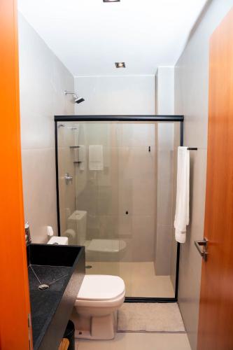 a bathroom with a toilet and a glass shower at Studio River 101 in Pôrto de Pedras