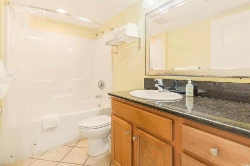 a bathroom with a sink and a toilet and a mirror at Bay View Resort 1202 in Myrtle Beach