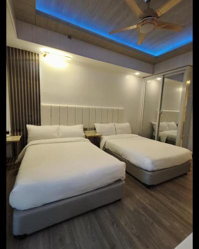 a room with two beds and a ceiling fan at 1BR Condo near Tourist Spots in Baguio