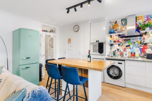 a kitchen with a table and two blue chairs at Stylish 2 bed Central London in London