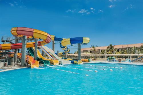 a water slide in a swimming pool at Crystals Beach Resort Belle Mare, a member of Radisson Individuals in Belle Mare