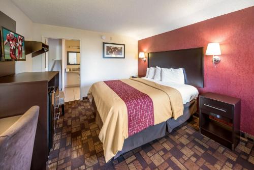 a hotel room with a large bed and a bathroom at Red Roof Inn Anderson, IN in Anderson