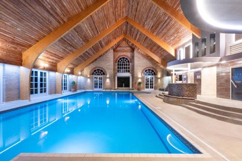 a large indoor pool with a wooden ceiling at Park Farm Hotel in Norwich