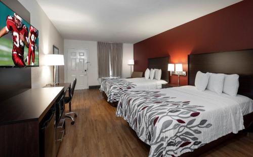 a hotel room with two beds and a television at Red Roof Inn Gulf Shores in Gulf Shores