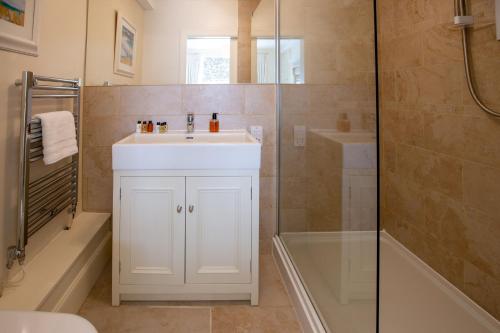 a bathroom with a white sink and a shower at Wilson House in St. Andrews