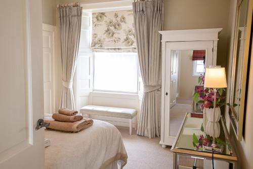 a bedroom with a bed with a window and a windowseatigunigun at Wilson House in St. Andrews