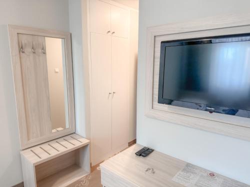 a living room with a flat screen tv on a wall at Złote Runo - Kameralny hotelik & Restauracja in Karolina