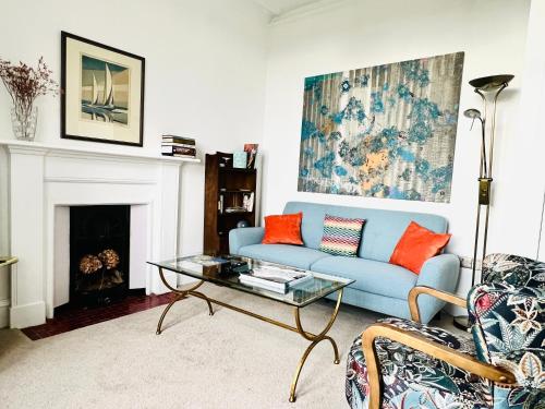 a living room with a blue couch and a fireplace at Ard Solas in Crieff