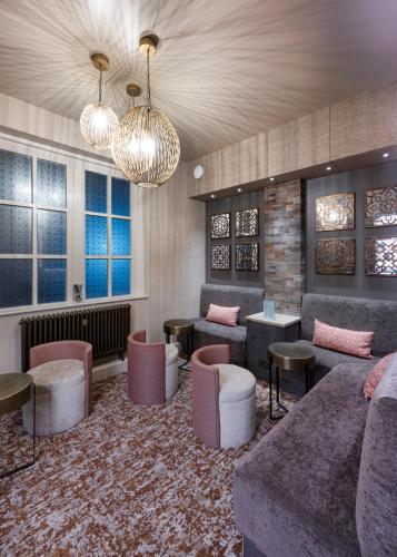 a lobby with couches and chairs and windows at Park Farm Hotel in Norwich