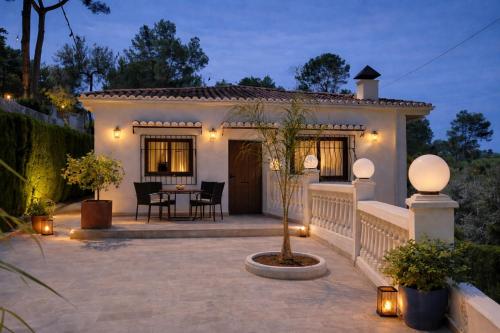 a house with a patio with a table and chairs at Wonderful Villa, Heated Pool, Near Beautiful Xàtiva Town in Alboy