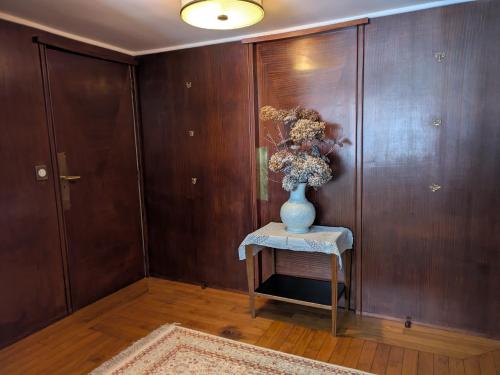 a vase with flowers on a table in a room at La Closerie in Droue-sur-Drouette