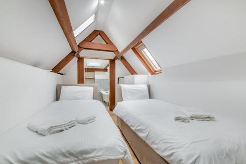 two beds in a room with white sheets at 2 Bed in Latton oc-c34099 in Clapton