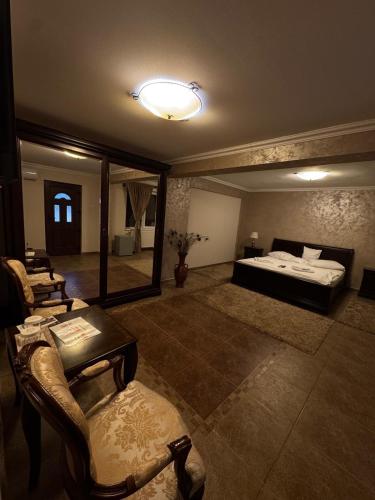 a large room with a bed and chairs in it at CASA LUCA in Moldova Nouă