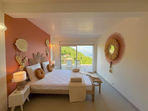 a bedroom with a large bed and a large window at Villa Altaïa - Sea View & Infinity Pool in Les Trois-Îlets