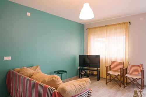 a living room with a couch and a television at A Praia- My Own Paradise T1 in Figueira da Foz