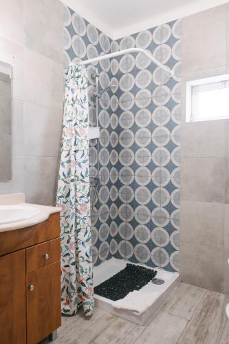 a bathroom with a shower with a shower curtain at A Praia- My Own Paradise T1 in Figueira da Foz