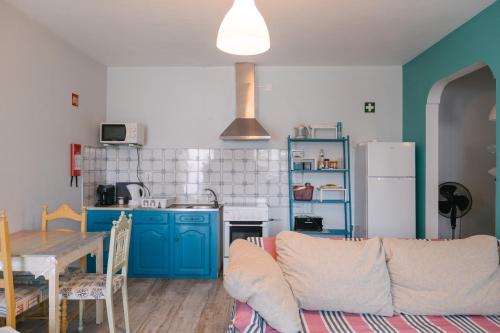 a living room with a couch and a kitchen at A Praia- My Own Paradise T1 in Figueira da Foz