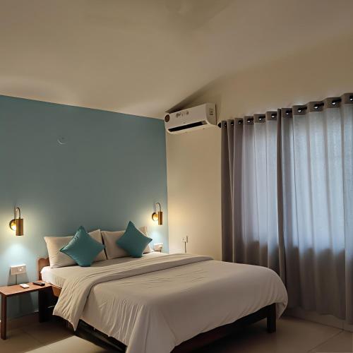 a bedroom with a large bed with blue pillows at RAIAl DWELLING PLACE in Calangute