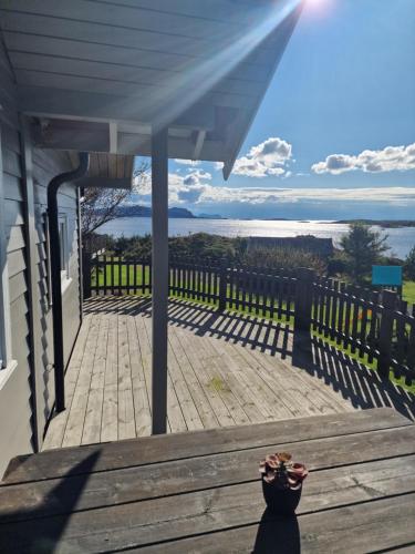 a woman standing on the porch of a house at Færøya 49 in Nekkøyane