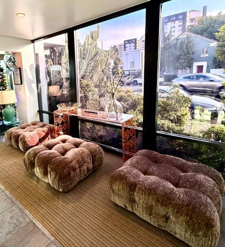 a room with three ottomans in front of a large window at Park Plaza Lodge in Los Angeles